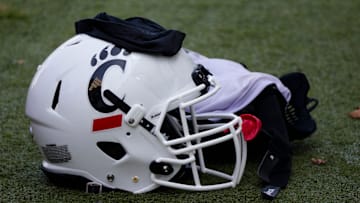 A Cincinnati Bearcats helmet and gloves sits on the turf during Cincinnati Bearcats football practice Wednesday, July 31, 2019, at the University of Cincinnati. 

Cincinnati Bearcats 107