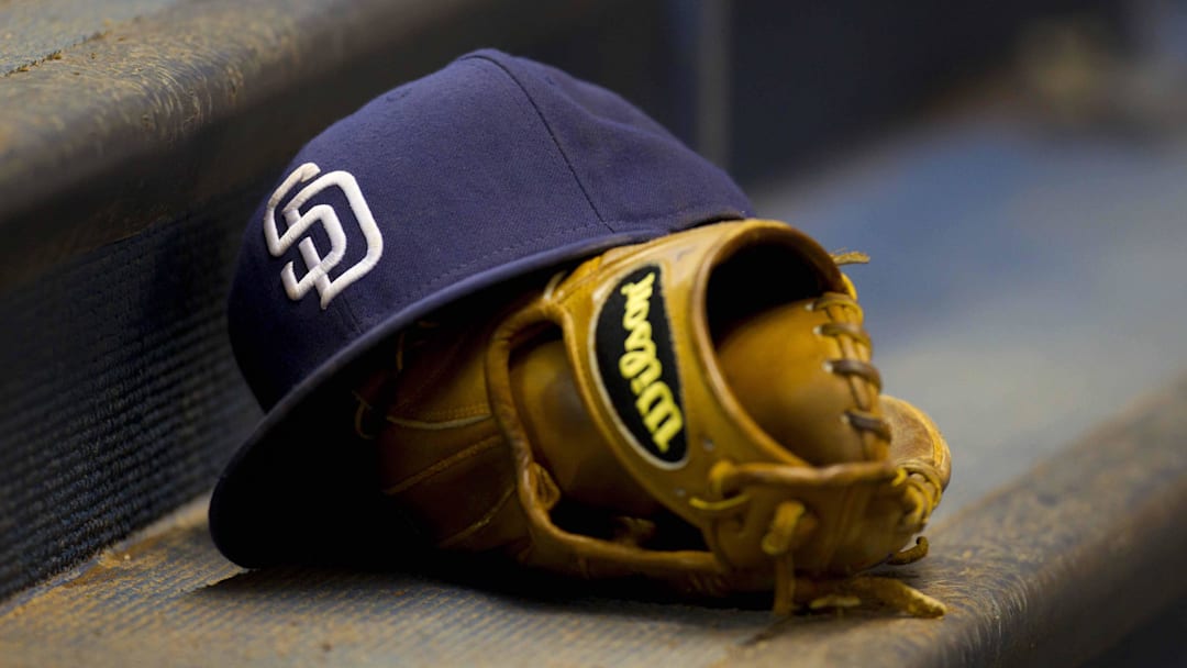 A San Diego Padres hat rests on a glove during the game against the Milwaukee Brewers at Miller Park.  The Brewers defeated the Padres 4-3 on May 9, 2011.