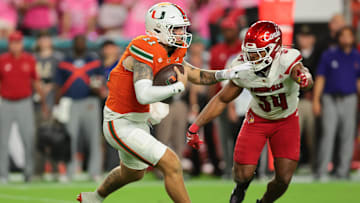 Oct 17, 2025; Miami Gardens, Florida, USA; Miami Hurricanes quarterback Carson Beck (11) carries the football against Louisville Cardinals linebacker T.J. Quinn (34) during the third quarter at Hard Rock Stadium. Mandatory Credit: Sam Navarro-Imagn Images