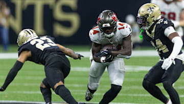 Oct 13, 2024; New Orleans, Louisiana, USA;  Tampa Bay Buccaneers wide receiver Chris Godwin (14) slips between New Orleans Saints cornerback Marshon Lattimore (23) and New Orleans Saints cornerback Kool-Aid McKinstry (14) during the first half at Caesars Superdome. Mandatory Credit: Stephen Lew-Imagn Images