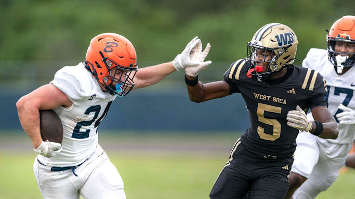 Benjamin running back Phoenix Donghia escapes the grasp of West Boca Raton's Jaydin Broadnax during their game on August 22, 2024 in Boca Raton, Florida. Benjamin running back Phoenix Donghia escapes the grasp of West Boca Raton's Jaydin Broadnax during their game on August 22, 2024 in Boca Raton, Florida.