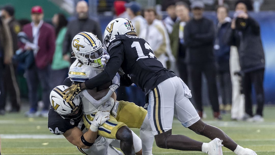 Dec 27, 2024; Birmingham, AL, USA;  Vanderbilt Commodores linebackers Nick Rinaldi (24) and Jeffrey Ugochukwu (12) stop Georgia Tech Yellow Jackets running back Jamal Haynes (11) during the first half of the 2024 Birmingham Bowl at Protective Stadium. Mandatory Credit: Vasha Hunt-Imagn Images