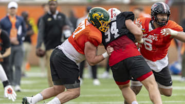 Jan 30, 2025; Mobile, AL, USA; National team offensive lineman Grey Zabel of North Dakota State (77) and National team offensive lineman Caleb Rogers of Texas Tech (76) battle with National team defensive lineman Ty Robinson of Nebraska (94) during Senior Bowl practice for the National team at Hancock Whitney Stadium. 