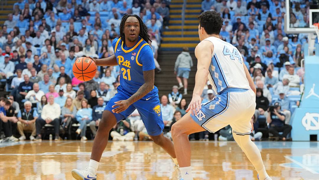 Feb 14, 2026; Chapel Hill, North Carolina, USA; Pittsburgh Panthers guard MacAri Moore (21) with the ball as North Carolina Tar Heels guard Luka Bogavac (44) defends in the first half at Dean E. Smith Center. Mandatory Credit: Bob Donnan-Imagn Images