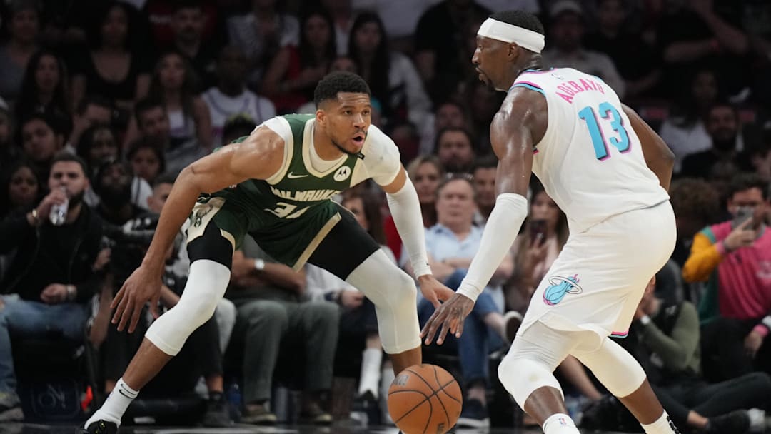 Apr 5, 2025; Miami, Florida, USA;  Miami Heat center Bam Adebayo (13) looks to pass the ball as Milwaukee Bucks forward Giannis Antetokounmpo (34) defends during the second half at Kaseya Center. Mandatory Credit: Jim Rassol-Imagn Images