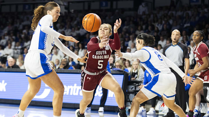 Mar 1, 2026; Lexington, Kentucky, USA; South Carolina Gamecocks guard Tessa Johnson (5) tries to get past Kentucky Wildcats forward Amelia Hassett (32) and guard Asia Boone (8) during the first quarter at Memorial Coliseum. Mandatory Credit: Arden Barnes-Imagn Images
