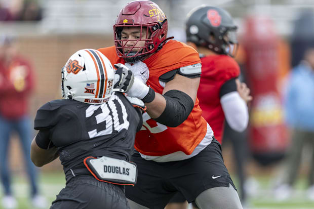 Jalen Travis of Iowa State (72) works against Collin Oliver of Oklahoma State (30) during Senior Bowl practice.