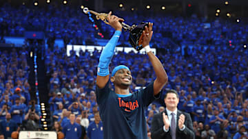 Shai Gilgeous-Alexander hoists the NBA MVP trophy before Game 2