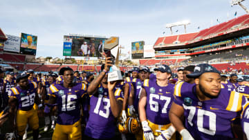 Jan 1, 2024; Tampa, FL, USA; LSU Tigers defensive end Bradyn Swinson (13) and LSU Tigers defensive end Da'Shawn Womack (16) hold up the Reliaquest Bowl championship trophy after the game against the Wisconsin Badgers at the Reliaquest Bowl at Raymond James Stadium. Mandatory Credit: Matt Pendleton-USA TODAY Sports