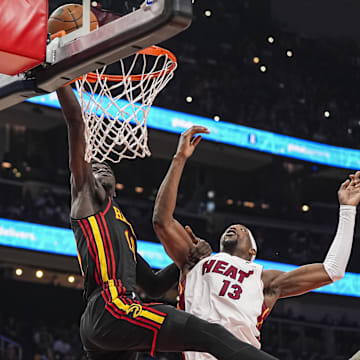Apr 18, 2025; Atlanta, Georgia, USA; Atlanta Hawks forward Mouhamed Gueye (18) tries to convert a pass behind Miami Heat center Bam Adebayo (13) during the first half at State Farm Arena. Mandatory Credit: Dale Zanine-Imagn Images