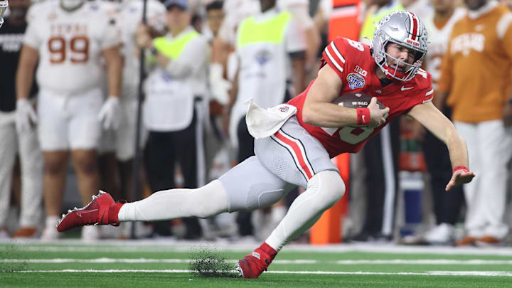Ohio State Buckeyes quarterback Will Howard (18) trips during the fourth quarter of the College Football Playoff semifinal against the Texas Longhorns in the Cotton Bowl at AT&T Stadium. Ohio State Buckeyes quarterback Will Howard (18) trips during the fourth quarter of the College Football Playoff semifinal against the Texas Longhorns in the Cotton Bowl at AT&T Stadium.