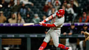 Philadelphia Phillies designated hitter Kyle Schwarber (12) hits a solo home run in the ninth inning against the Colorado Rockies at Coors Field.