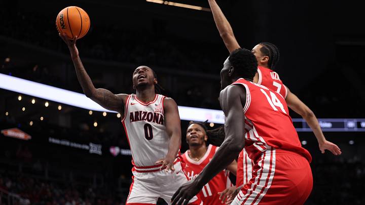 Mar 14, 2026; Kansas City, MO, USA; Arizona Wildcats guard Jaden Bradley (0) drives to the hoop past Houston Cougars forward Kalifa Sakho (14) and guard Milos Uzan (7) during the first half during the men's Big 12 Conference Tournament Championship at T-Mobile Center. Mandatory Credit: William Purnell-Imagn Images