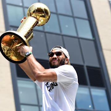 Boston Celtics player Jayson Tatum holds the Larry O'Brien trophy during the Boston Celtics Championship parade.