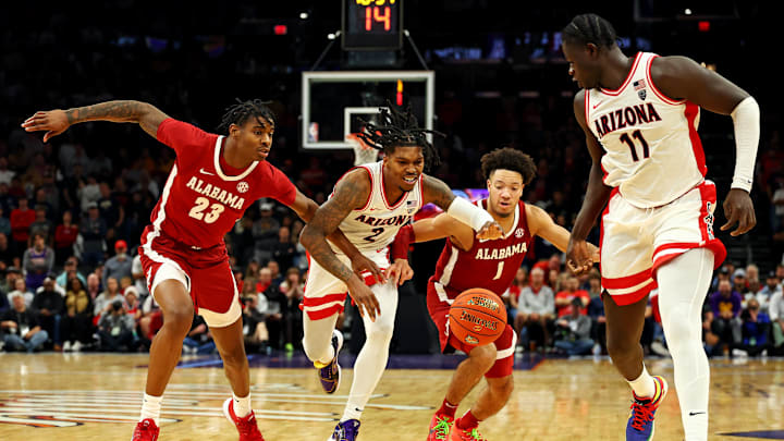 Dec 20, 2023; Phoenix, Arizona, USA; Arizona Wildcats guard Caleb Love (2) goes for the ball against Alabama Crimson Tide forward Nick Pringle (23) and guard Mark Sears (1) during the second half in the Hall of Fame Series at Footprint Center. Mandatory Credit: Mark J. Rebilas-Imagn Images