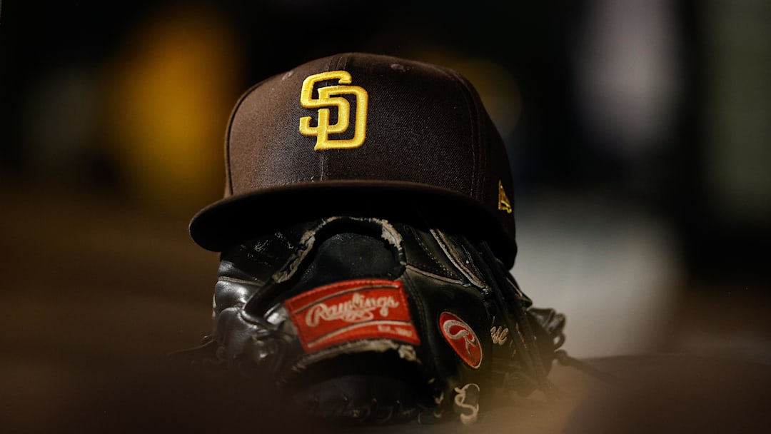 Denver, Colorado, USA; A detail view of a San Diego Padres hat on a glove in the dugout in the ninth inning against the Colorado Rockies at Coors Field.
