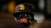 Jun 17, 2022; Denver, Colorado, USA; A detail view of a San Diego Padres hat on a glove in the dugout in the ninth inning against the Colorado Rockies at Coors Field. 