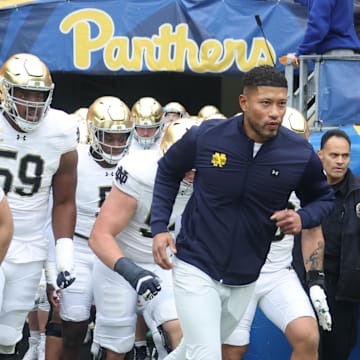 Nov 15, 2025; Pittsburgh, Pennsylvania, USA;  Notre Dame Fighting Irish head coach Marcus Freeman (right) leads the team onto the field to play the Pittsburgh Panthers at Acrisure Stadium. 
