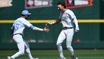 Jun 14, 2024; Omaha, NE, USA;  North Carolina Tar Heels center fielder Vance Honeycutt (7) celebrates with third baseman Gavin Gallaher (5) after driving in the winning run against the Virginia Cavaliers during the ninth inning at Charles Schwab Filed Omaha. Mandatory Credit: Steven Branscombe-USA TODAY Sports