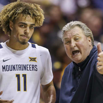 Jan 20, 2020; Morgantown, West Virginia, USA; West Virginia Mountaineers head coach Bob Huggins talks with West Virginia Mountaineers forward Emmitt Matthews Jr. (11) during the second half at WVU Coliseum. Mandatory Credit: Ben Queen-Imagn Images