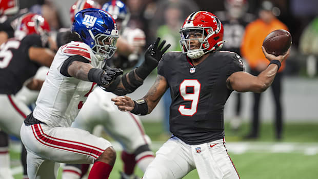 Atlanta Falcons quarterback Michael Penix Jr. (9) passes under pressure from New York Giants linebacker Kayvon Thibodeaux (5)