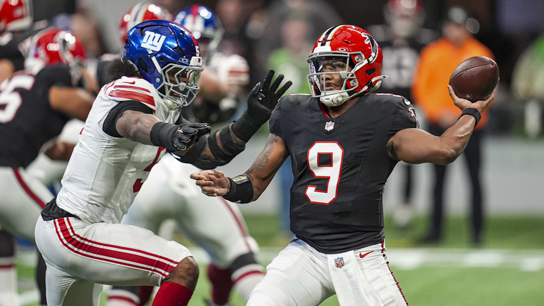 Dec 22, 2024; Atlanta, Georgia, USA; Atlanta Falcons quarterback Michael Penix Jr. (9) passes under pressure from New York Giants linebacker Kayvon Thibodeaux (5) during the first quarter at Mercedes-Benz Stadium. Mandatory Credit: Dale Zanine-Imagn Images