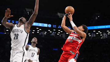 Oct 14, 2024; Brooklyn, New York, USA; Washington Wizards shooting guard Jordan Poole (13) shoots a jump shot against Brooklyn Nets power forward Dorian Finney-Smith (28) and Brooklyn Nets point guard Dennis Schroder (17) during the second half at Barclays Center. Mandatory Credit: Gregory Fisher-Imagn Images