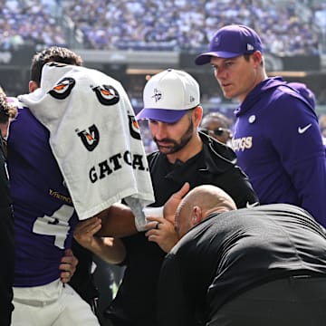 Aug 9, 2025; Minneapolis, Minnesota, USA; Minnesota Vikings wide receiver Rondale Moore (4) is attended to by head coach Kevin O'Connell and trainers after suffering a lower leg injury during the second quarter against the Houston Texans at U.S. Bank Stadium. Mandatory Credit: Jeffrey Becker-Imagn Images