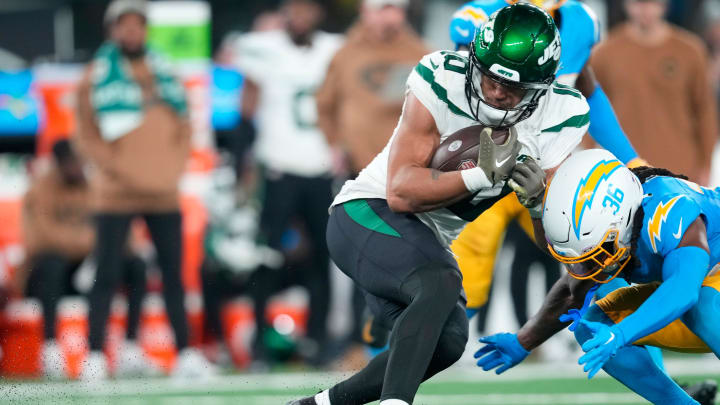 New York Jets wide receiver Allen Lazard (10) holds onto the ball before being taken down by Los Angeles Chargers cornerback Ja'Sir Taylor (36), in the fourth quarter, Monday, November 26, 2023.