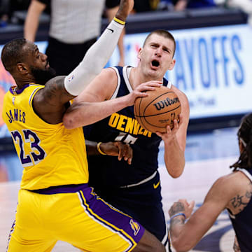 Apr 29, 2024; Denver, Colorado, USA; Denver Nuggets center Nikola Jokic (15) drives to the net against Los Angeles Lakers forward LeBron James (23) in the fourth quarter during game five of the first round for the 2024 NBA playoffs at Ball Arena. Mandatory Credit: Isaiah J. Downing-Imagn Images
