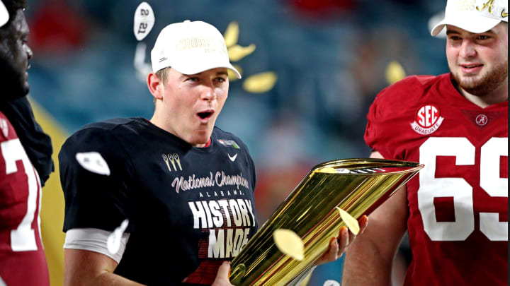 Jan 11, 2021; Miami Gardens, Florida, USA; Alabama Crimson Tide quarterback Mac Jones (10) celebrates with the CFP National Championship trophy after beating the Ohio State Buckeyes in the 2021 College Football Playoff National Championship Game. 