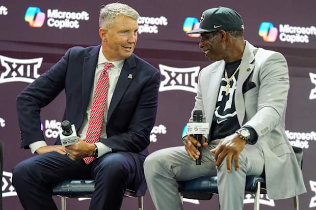 Jul 9, 2025; Frisco, TX, USA; Arizona head coach Brent Brennan and Colorado head coach Deion Sanders talk on stage during 202