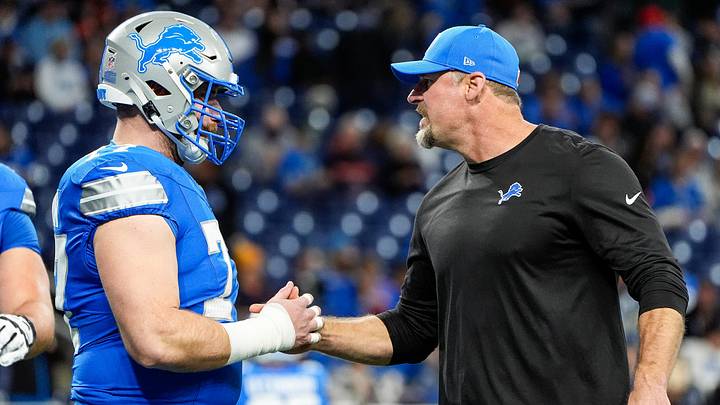 Detroit Lions head coach Dan Campbell shakes hands with center Frank Ragnow (77) warm up before the game between Detroit Lions and Chicago Bears at Ford Field in Detroit on Thursday, Nov. 28, 2024.