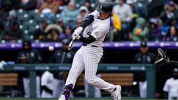 Apr 4, 2025; Denver, Colorado, USA; Colorado Rockies first baseman Michael Toglia (4) hits a single in the fourth inning against the Athletics at Coors Field. Mandatory Credit: Isaiah J. Downing-Imagn Images