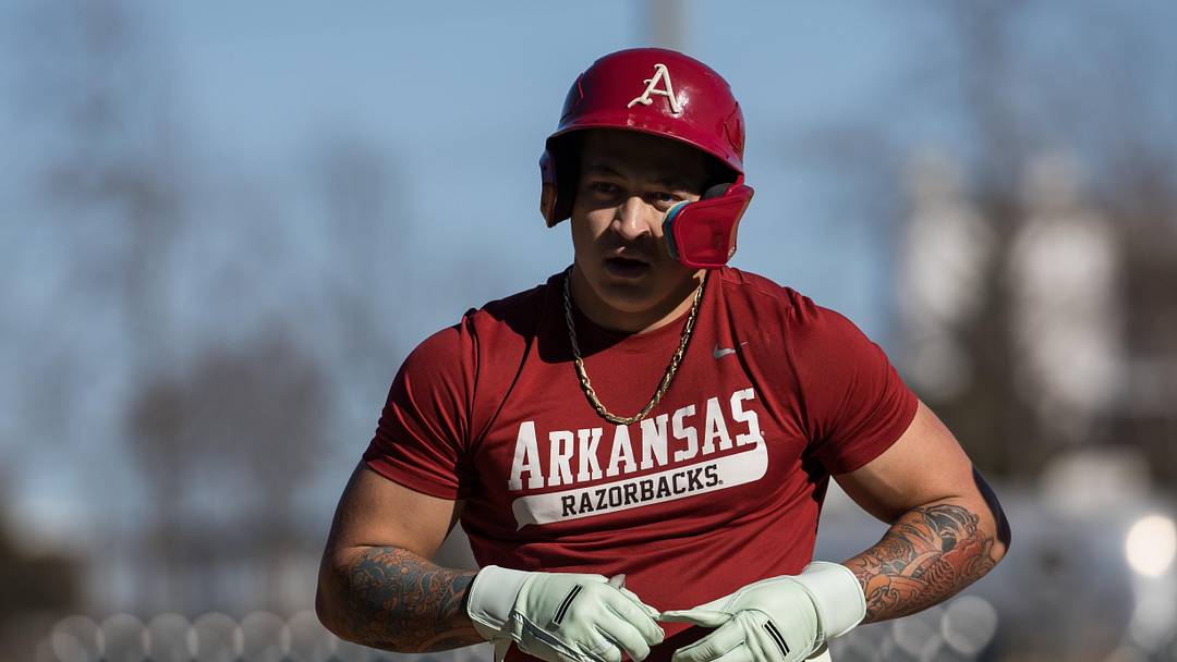 Arkansas outfielder Kuhio Aloy takes a glove off after reaching first base on a single during the third inning of the Razorbacks' scrimmage at Baum-Walker Stadium. 