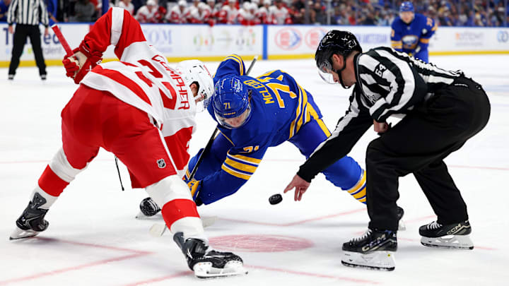 Oct 22, 2025; Buffalo, New York, USA;  The linesman drops the puck for a face-off between Detroit Red Wings left wing J.T. Compher (37) and Buffalo Sabres center Ryan McLeod (71) during the second period at KeyBank Center. Mandatory Credit: Timothy T. Ludwig-Imagn Images