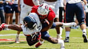 Sep 6, 2025; Raleigh, North Carolina, USA; North Carolina State Wolfpack offensive lineman Rico Jackson (64) tackles Virginia Cavaliers running back J'Mari Taylor (3) during the first half of the game at Carter-Finley Stadium. Mandatory Credit: Jaylynn Nash-Imagn Images