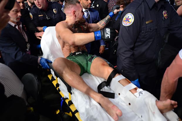 Conor McGregor is carried off a stretcher following an injury suffered against Dustin Poirier during UFC 264.