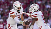South Dakota quarterback Aidan Bouman hands the football to running back Charles Pierre Jr.