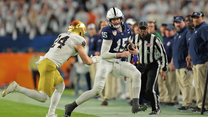 Penn State Nittany Lions quarterback Drew Allar (15) runs the ball pressured by Notre Dame Fighting Irish linebacker Jack Kiser (24) in the first half in the Orange Bowl at Hard Rock Stadium. Penn State Nittany Lions quarterback Drew Allar (15) runs the ball pressured by Notre Dame Fighting Irish linebacker Jack Kiser (24) in the first half in the Orange Bowl at Hard Rock Stadium.