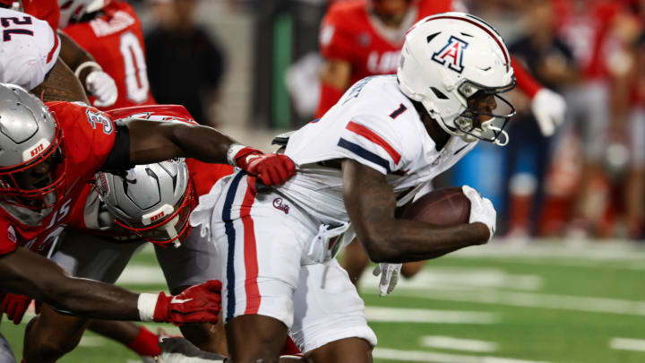 Aug 31, 2024; Tucson, Arizona, USA; Arizona Wildcats running back Jacory Croskey-Merritt (1) runs through New Mexico Lobos linebacker Randolph Kpai (33) during third quarter at Arizona Stadium