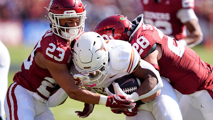 Oklahoma Sooners defensive back Eli Bowen (23) and Danny Stutsman (28) tackle Texas Longhorns running back Jaydon Blue (23) in the first half of the Red River Rivalry game, Oct. 12, 2024, at the Cotton Bowl Stadium in Dallas, Texas. Oklahoma Sooners defensive back Eli Bowen (23) and Danny Stutsman (28) tackle Texas Longhorns running back Jaydon Blue (23) in the first half of the Red River Rivalry game, Oct. 12, 2024, at the Cotton Bowl Stadium in Dallas, Texas.