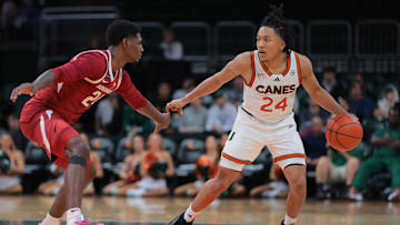 Dec 3, 2024; Coral Gables, Florida, USA; Miami Hurricanes guard Nijel Pack (24) dribblers the basketball as Arkansas Razorbacks forward Billy Richmond III (24) defends during the second half at Watsco Center. Mandatory Credit: Sam Navarro-Imagn Images