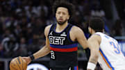 Mar 15, 2025; Detroit, Michigan, USA;  Detroit Pistons guard Cade Cunningham (2) dribbles defended by Oklahoma City Thunder forward Kenrich Williams (34) in the first half at Little Caesars Arena. Mandatory Credit: Rick Osentoski-Imagn Images