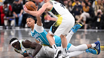 Dec 8, 2024; Indianapolis, Indiana, USA; Charlotte Hornets guard Isaiah Wong (21) tips a loose ball away from Indiana Pacers guard T.J. McConnell (9) during the first half at Gainbridge Fieldhouse. Mandatory Credit: Robert Goddin-Imagn Images 