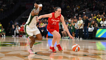Jun 24, 2025; Seattle, Washington, USA; Indiana Fever guard Caitlin Clark (22) advances the ball while guarded by Seattle Storm guard Erica Wheeler (17) during the second half at Climate Pledge Arena. Mandatory Credit: Steven Bisig-Imagn Images