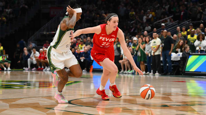 Jun 24, 2025; Seattle, Washington, USA; Indiana Fever guard Caitlin Clark (22) advances the ball while guarded by Seattle Storm guard Erica Wheeler (17) during the second half at Climate Pledge Arena. Mandatory Credit: Steven Bisig-Imagn Images
