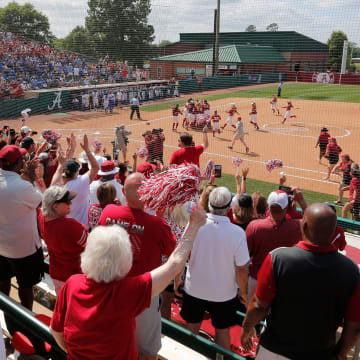 Fans cheer as Crimson Tide players rush the field after Alabama defeated Kentucky 4-1 to advance to
