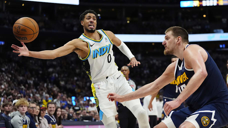Indiana Pacers guard Tyrese Haliburton and Denver Nuggets center Nikola Jokic reach for the ball.