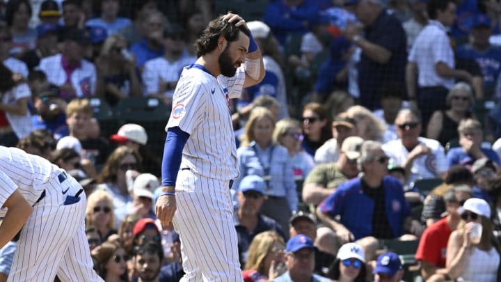 Aug 18, 2024; Chicago, Illinois, USA; Chicago Cubs shortstop Dansby Swanson (7) wipes his head after being called out on strikes with the bases loaded against the Toronto Blue Jays during the fourth inning at Wrigley Field.